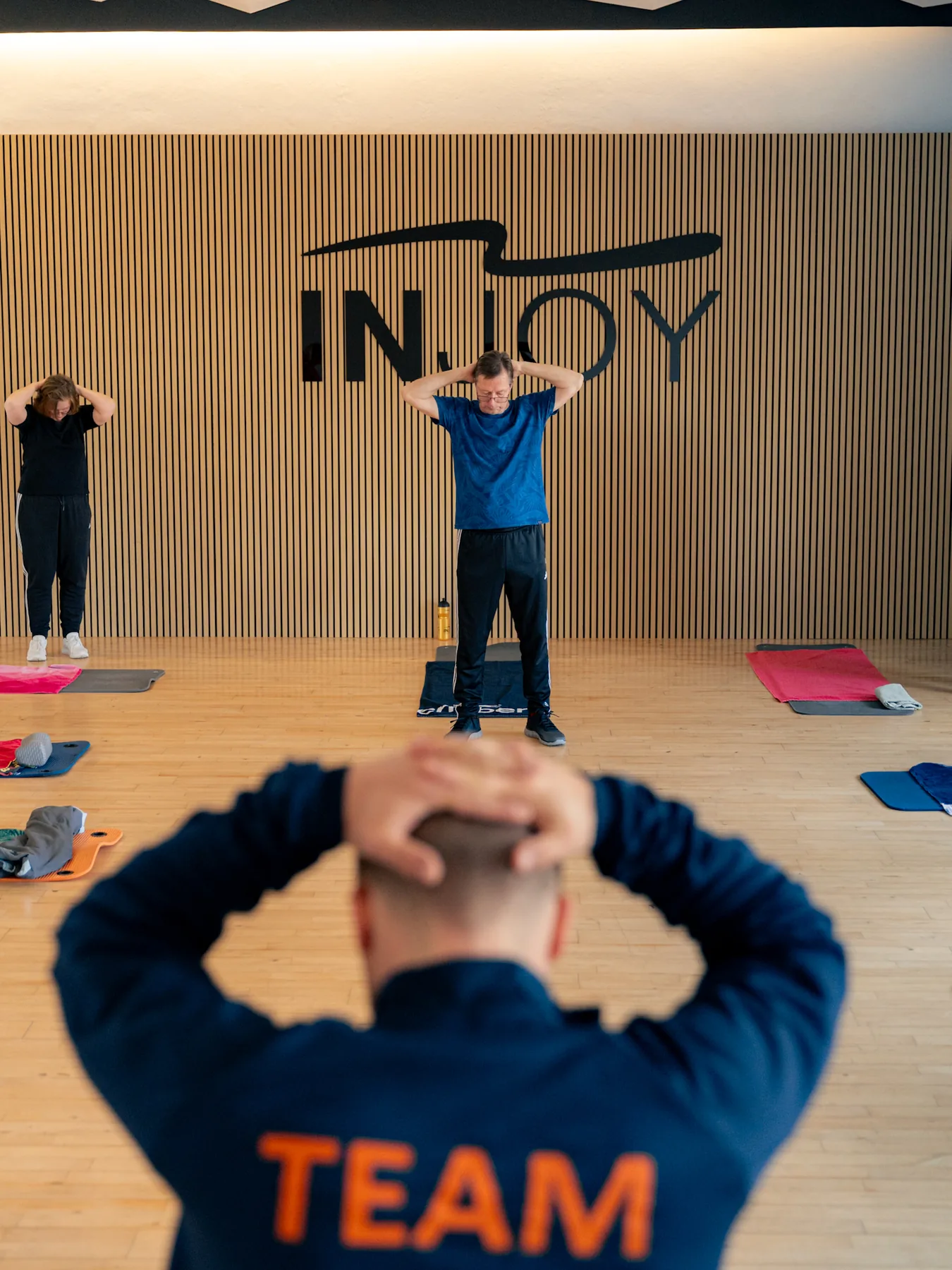 INJOY Trainer begleitet ein Mitglied beim Rücken- und Gelenktraining