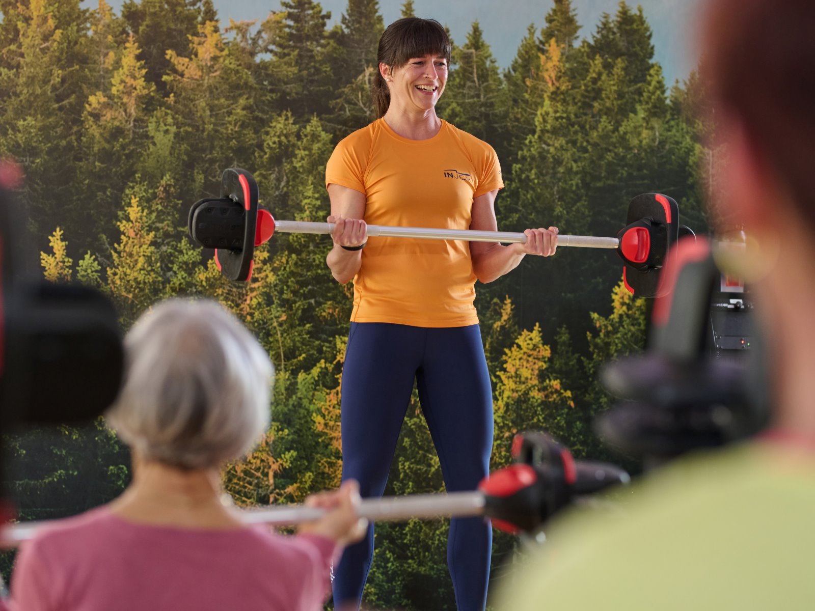 INJOY Kursleiterin leitet einen motivierenden Langhantelkurs persönlich an