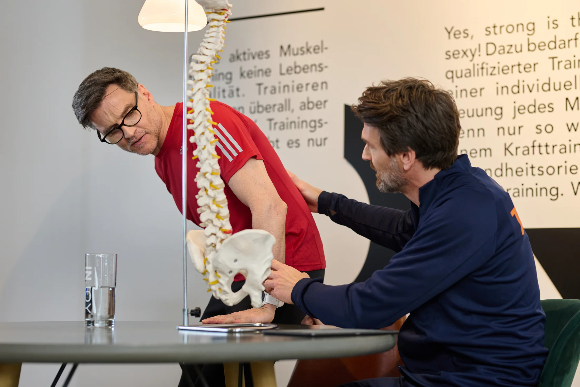 INJOY Trainer erklärt einem Mitglied Rücken und Wirbelsäule im persönlichen Gespräch