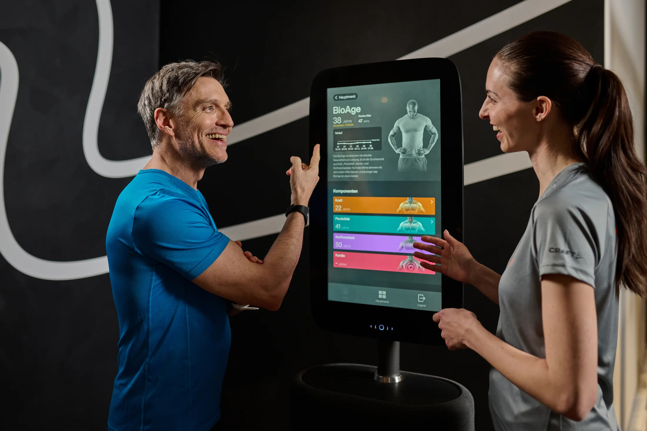 INJOY Trainer und Mitglied werten Fitness- und BioAge-Werte gemeinsam am Fitness Hub aus